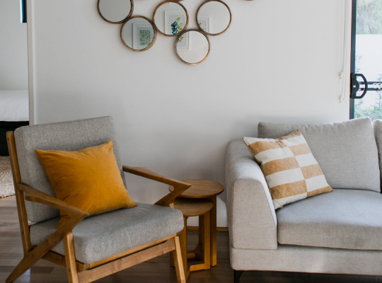 a sofa and a side chair with some pillows